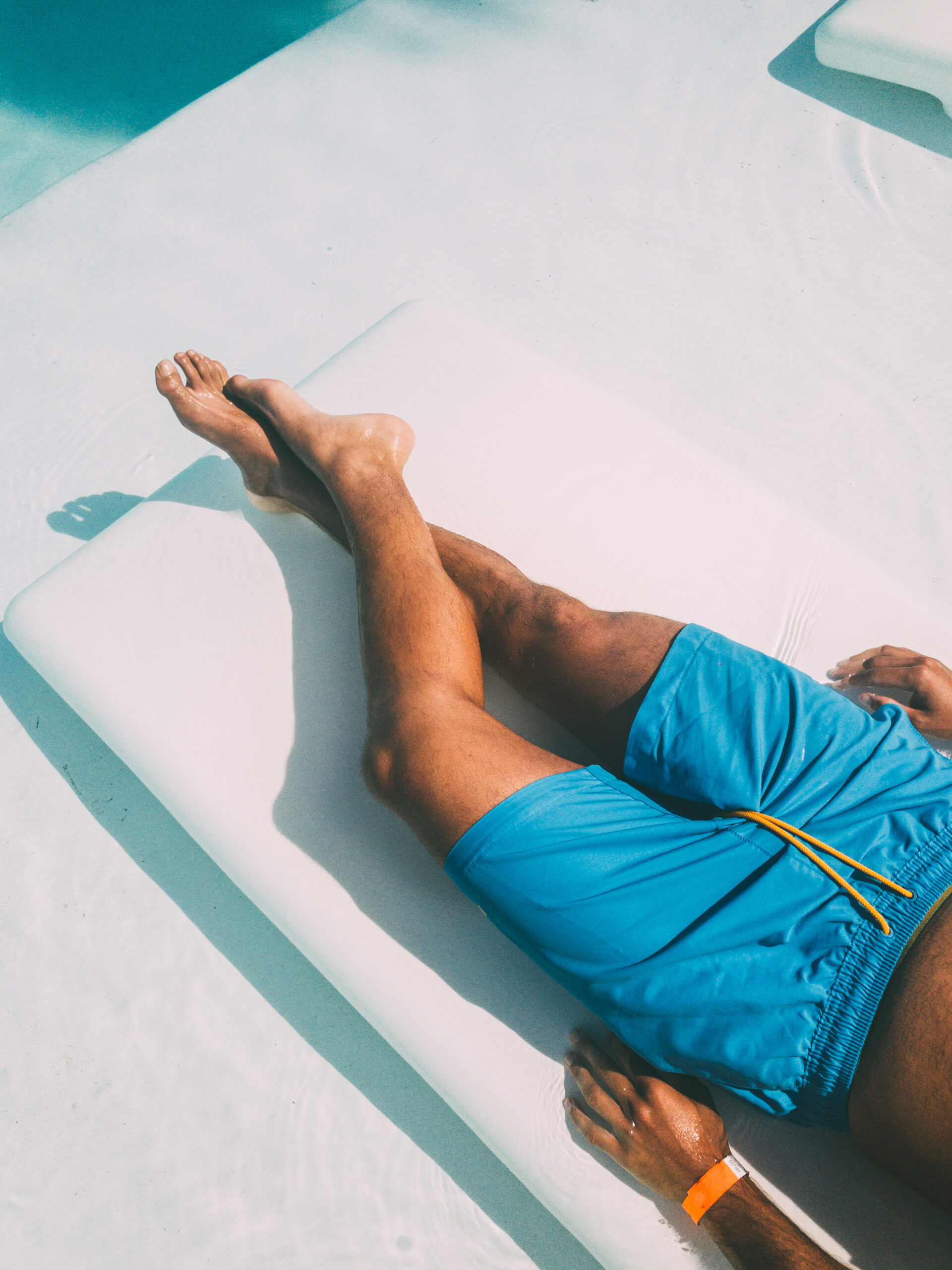 From above of male tourist lying on deckchair and sunbathing while relaxing during summer holiday